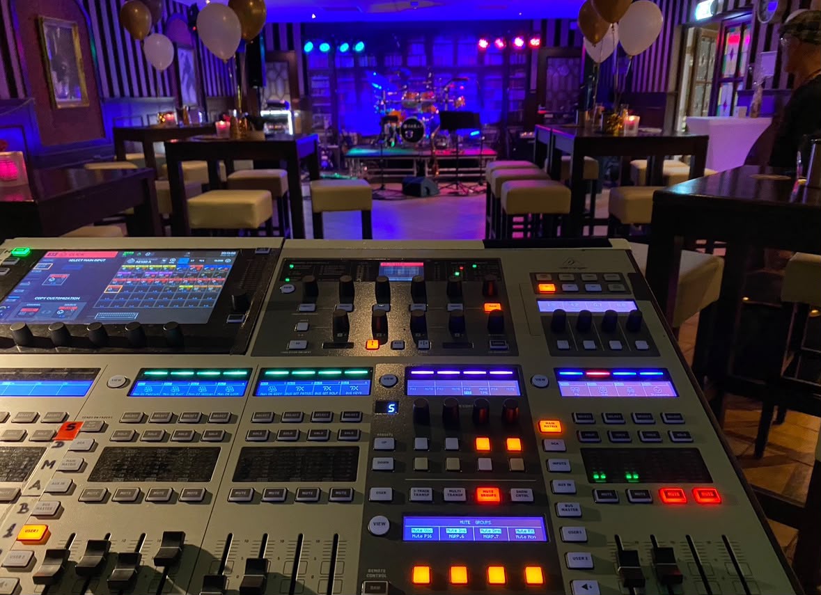 Professionele mengtafel met het verlichte podium van GoodTimes op de achtergrond